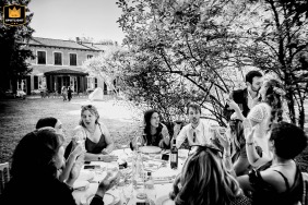 At the reception in CasaVilla in Cornaredo (Mi), the smiling newlyweds share a quiet, tender kiss next to a beautifully set table amidst their wedding celebration.
